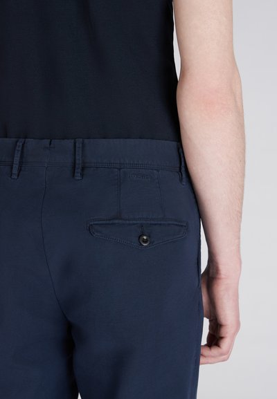 Pantalon bleu marine en coton avec une finition texturée, doté d'une poche arrière avec un rabat et un détail de bouton.