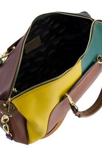 Leather handbag with multi-colored panels: burgundy, yellow, green, and brown. Interior features gold zipper and black fabric with logo pattern.