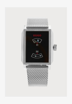 Hõbedane võrgust rihmaga käekell, ristkülikukese musta sihverplaadiga, punase "HUGO" logoga ning kahekordse digitaalaja näidikuga tundide ja minutite jaoks.