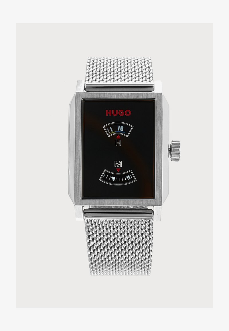 Montre-bracelet à bracelet en maille argentée avec cadran rectangulaire noir, logo rouge "HUGO" et double affichage numérique pour les heures et les minutes.