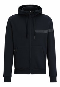 Marinblå zip-up hoodie tillverkad av mjukt tyg, med hög krage, justerbar dragsko på huven, fickor med dragkedja och en diskret logotyp.