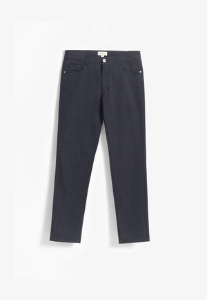 Vaqueros de algodón azul marino con un ajuste Slim, diseño de cinco bolsillos, cierre frontal de botón y costuras minimalistas a lo largo de las costuras.