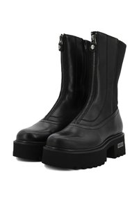 Para czarnych skórzanych botków do połowy łydki z masywnymi podeszwami platformowymi i srebrnymi zamkami błyskawicznymi z przodu, z widocznym przeszyciem i wytrzymałym bieżnikiem.