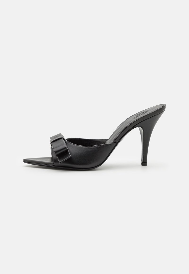 Sorte højhælede mules med spids tå og en stor dekorativ sløjfedetalje på overdelen. Glat lædertekstur og slank stiletto hæl.