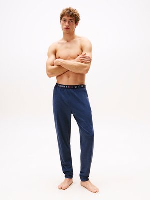 Pantalons de pyjama bleu marine avec une surface texturée et une taille élastique arborant le logo "TOMMY HILFIGER" dans des couleurs contrastées.