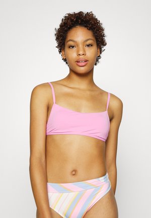 Top de biquíni rosa com alças finas, apresentando um decote reto. Combinado com um fundo de biquíni listrado multicolorido em tons pastéis.
