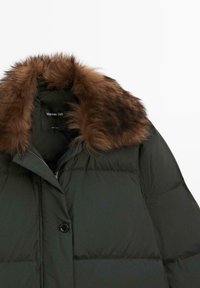 Zwarte donzen jas met een kraag van bruin imitatieleren bont, knoop- en ritssluiting, en een Massimo Dutti-label aan de binnenkant van de kraag.