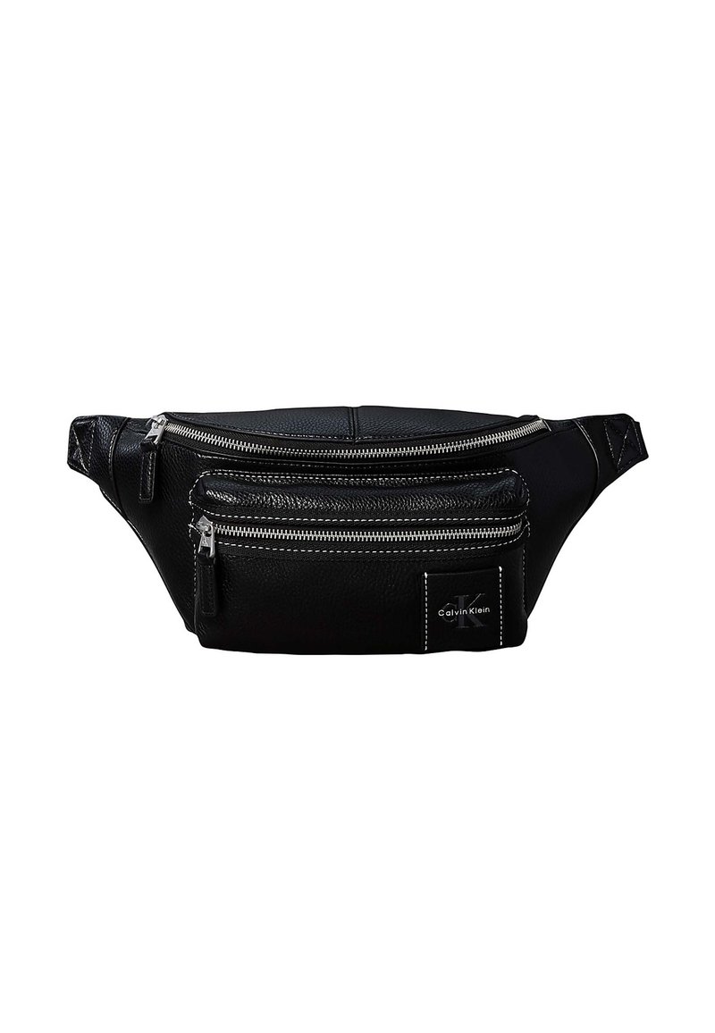 Banane en cuir noir Calvin Klein avec deux compartiments zippés et des sangles latérales réglables sur fond blanc.