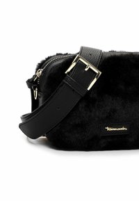 Borsa nera con texture in pelliccia artificiale, dotata di una tracolla in pelle nera, hardware dorato e una placca con logo sul lato.