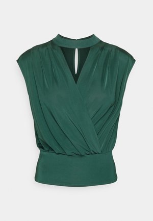 Mouwloze donker groene blouse met geplooide stof, een keyhole-halslijn en een aangesloten tailleband.