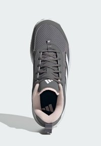 Szare buty sportowe z teksturowanym wierzchem, białymi akcentami i okrągłym noskiem. Sznurówki są ciemnoszare; wnętrze ma miękkie różowe wykończenie.
