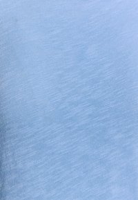 Vaaleansininen kangas, jossa on sileä pinta ja hienovarainen vaakasuora kuvio, esittelee pehmeää ja kevyttä materiaalia, joka sopii vaatteisiin.