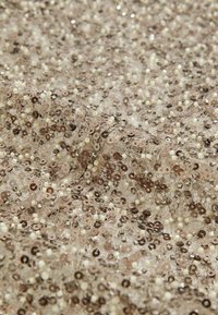 Pailletstof med en beige og brun farvepalet, prydet med små runde pailletter og reflekterende perler på en gennemsigtig bund. Teksturdetaljer synlige.