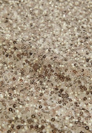 Tejido de lentejuelas con una paleta de colores en beige y marrón, que presenta pequeñas lentejuelas redondas y cuentas reflectantes sobre una base transparente. Detalle texturizado visible.