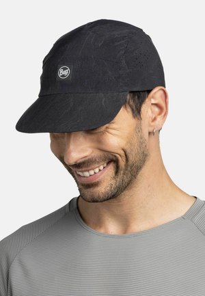 Man smiling, wearing a black Buff cap with ventilation holes, a small logo, and a gray textured shirt.