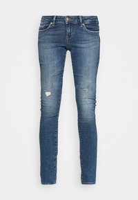 Jeans ajustados en denim azul oscuro, con áreas de rodillas desgastadas, diseño de cinco bolsillos y cierre de botón y cremallera. Textura suave.
