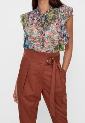 Bloemenpatroon, mouwloze blouse met ruches op de schouders, gecombineerd met een hoge taille roestkleurige broek met riem en ronde gesp.