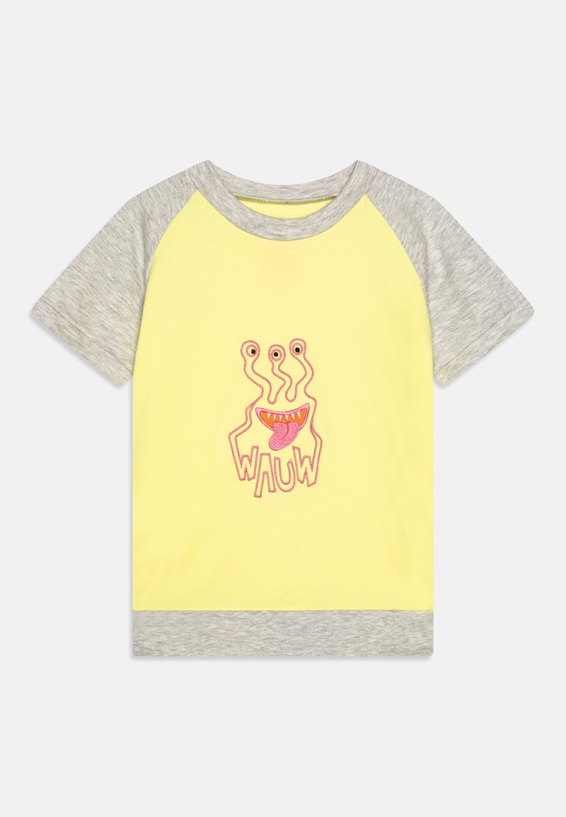 Camiseta de algodón amarilla con mangas raglán grises. En el centro presenta un gráfico de un monstruo colorido y caricaturesco con el texto "WAUW" debajo.