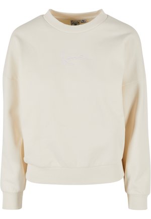 Kreemivärvi sweatshirt ribbesertud ümara kaelusega ja pikkade varrukatega. Ees on valge tõmmatud logo. Pehme tekstuur ja lõtv istuvus.