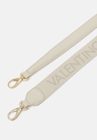 Bežna kožna i tkaninska narukvica s zlatnim dodacima. Jedan kraj ima glatku kožnu obradu, dok drugi prikazuje suptilan "VALENTINO" logotip.