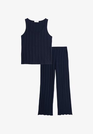Canotta a righe blu navy con spalline larghe abbinata a pantaloni coordinati con orlo scallop. Realizzata in tessuto morbido per garantire comfort.