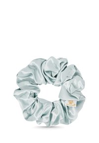 Satin haar scrunchie in lichtblauw met een glanzende textuur, voorzien van een klein gouden logo label. Cirkelvormig met een opgepakt stoffen ontwerp.