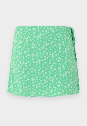 Zelenkavá mintová zavinovacia sukňa s drobným bielym kvetinovým vzorom a bočným zaväzovaním, zobrazená na svetlom pozadí.