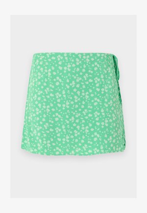 Zelenkavá mintová zavinovacia sukňa s drobným bielym kvetinovým vzorom a bočným zaväzovaním, zobrazená na svetlom pozadí.