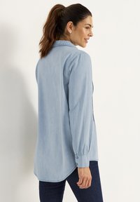 Lichtblauwe, lang-sleeve shirt van een zachte stof met een gebogen zoom en knoopmanchetten, met een klassieke kraag en een rugpasdetail.