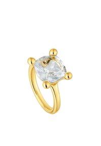 Anello d'oro con una grande pietra trasparente e sfaccettata sorretta da quattro eprna arrotondati. Fibbia liscia e lucidata con un profilo curvo.