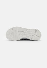 Calzature Adidas con suola in gomma bianca testurizzata caratterizzata da un motivo geometrico, progettata per offrire aderenza e durata.