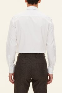 Vit långärmad skjorta med klassisk krage, knappmanschetter och slät textur, kombinerad med mörkbruna texturerade byxor med bakfickor.