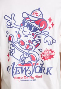 Camiseta de algodón blanca con un gráfico colorido de una rebanada de pizza de dibujos animados con gafas de sol y una gorra. El texto incluye "Nueva York" y "Pizza en mi mente".