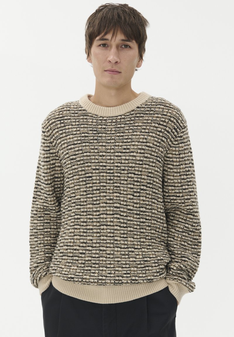 Pletena pulover s teksturiranim vzorcem v bež in črni barvi, z okroglim izrezom in rebrastimi manšeti ter robom, v sproščenem kroju.