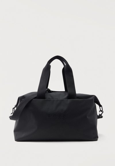 Sac de sport rectangulaire noir avec double poignée, bandoulière réglable et logo "BOSS" embossé au centre avant.