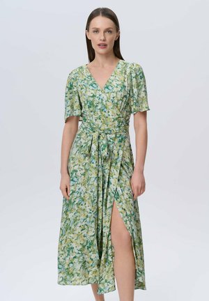 Bloemrijke wikkeljurk met een V-hals, korte pofmouwen en een strik taille. Heeft groene en gele abstracte patronen en een hoge split aan één kant.