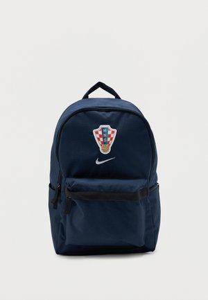 Sac à dos bleu marine avec l'écusson du club de football de Zagreb et le logo blanc Nike swoosh, doté d'une poche avant zippée et d'une poignée supérieure.