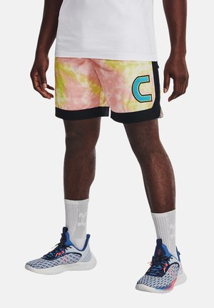 Mann trägt pink-gelbe Batik-Shorts mit einem blauen Buchstaben C, weiße Socken und blau-weiße Sportschuhe.