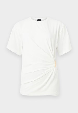 Maglietta bianca a maniche corte con scollo rotondo e dettaglio laterale arricciato fissato da una piccola clip beige.