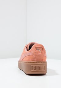 Basket PUMA en daim rose doux avec un bout arrondi, semelle en caoutchouc beige et détail de logo à l'arrière. Accentuation de couture minimale.