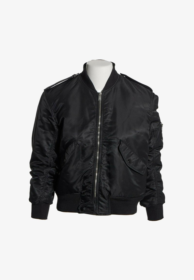 Veste bomber en satin noir avec fermeture éclair à l'avant, poignets et ceinture côtelés, poches à rabat et épaulettes sur un torse de mannequin blanc.