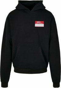 Black hooded sweatshirt with a front pocket, featuring a red and white name tag graphic that reads "HEY! MY NAME IS." Cotton blend material.