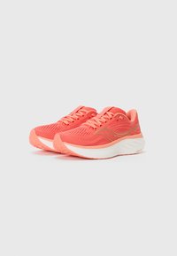 Les chaussures de course corail sont dotées d'une tige en mesh respirant, d'une languette rembourrée, d'accents réfléchissants et d'une semelle blanche rembourrée avec une texture antidérapante.