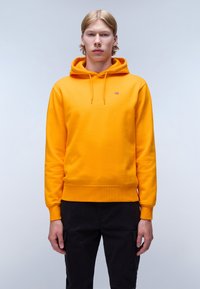 Gele hoodie van zacht materiaal met een voorzak in kangoeroestijl, een verstelbare capuchon met trekkoord en geribbelde boorden. Bevat een klein logo op de borst.