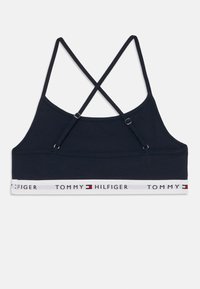 Sostén de algodón navy con tirantes entrecruzados, que presenta una banda blanca en contraste con el logotipo y emblema de "TOMMY HILFIGER".
