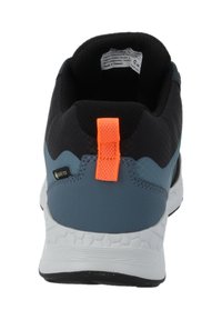 Vista posteriore di una scarpa sportiva nera e blu con suola bianca e linguetta arancione sul tallone, con etichetta Gore-Tex.