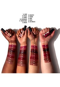 Three arms displaying various lip product shades, with swatches in deep reds and pinks. Each product labeled with specific color numbers.