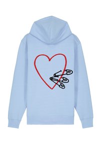 Ljusblå hoodie med ett rött broderat hjärta och tre svarta säkerhetsnålar tvärs över mitten. Mjuk tygkvalitet och aktsamma manschetter.