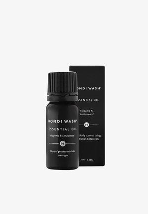 Bouteille en verre noir d'huile essentielle avec un capuchon noir texturé. La boîte présente un texte blanc mettant en avant "Bondi Wash", "Fragonia & Bois de Santal."