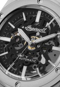 Movimento dell'orologio automatico trasparente con dettagli neri e argento, che presenta un quadrante decorato, lancette argento e accenti dorati.